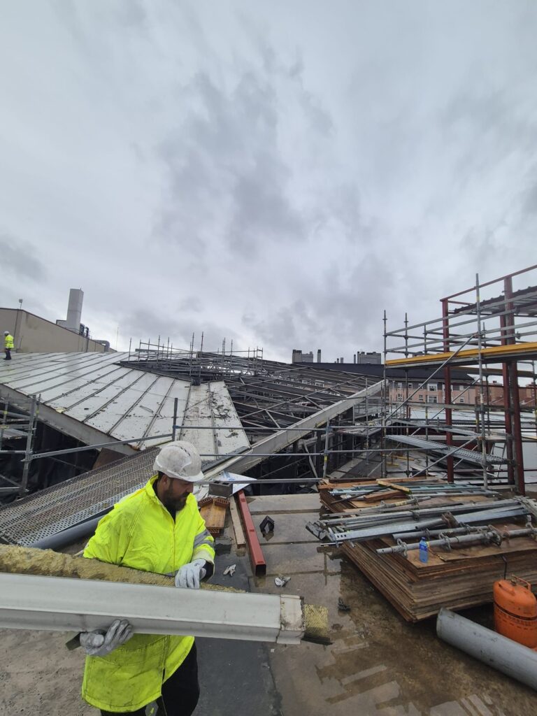 Operario de Recuperaciones Los Gemelos realizando el desmontaje técnico de una cubierta de nave industrial dañada en Madrid